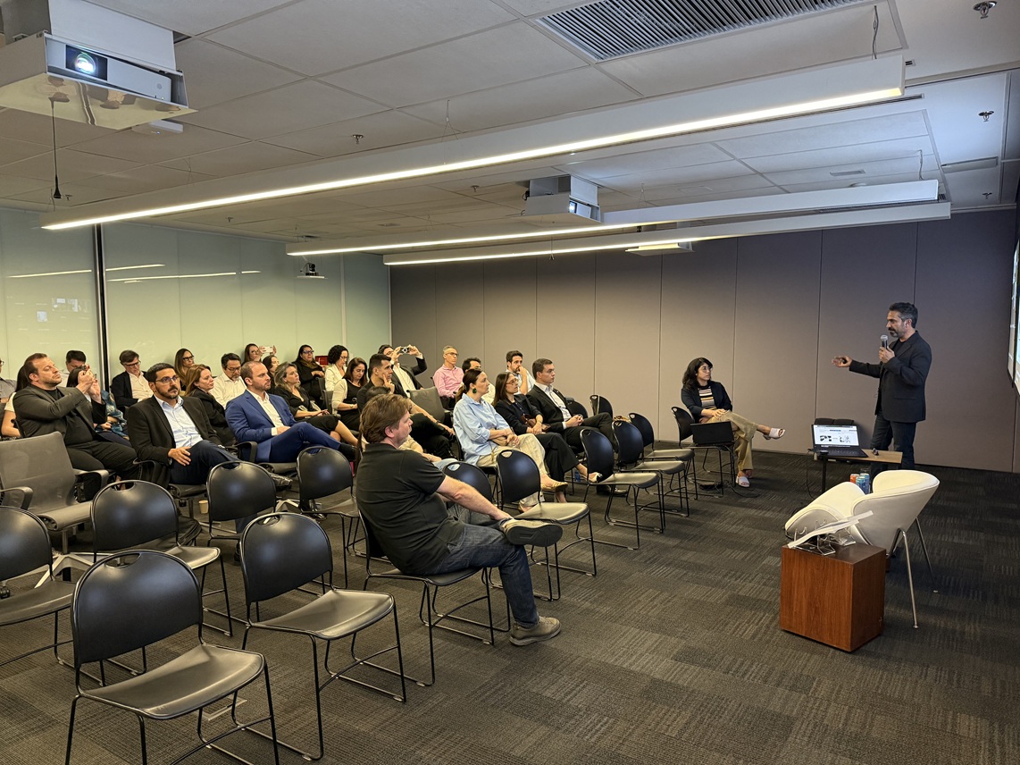 Mori Kabiri presenting to a seated audience in a conference room